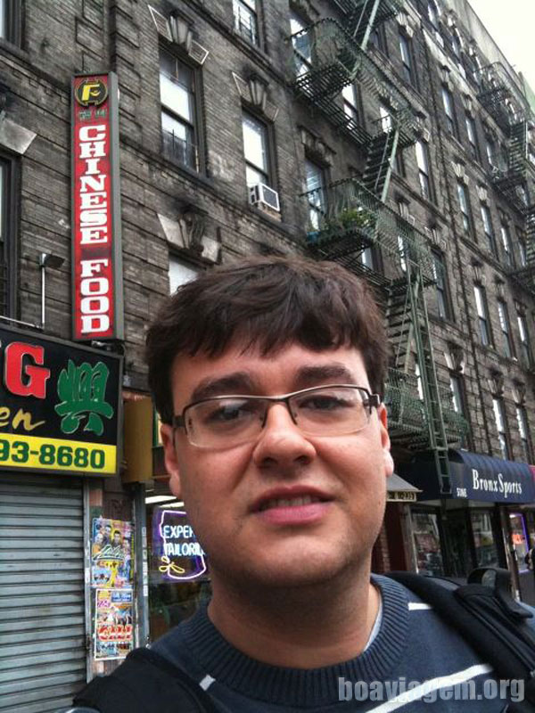 Eu em uma das ruas do Bronx com os prédios ao fundo