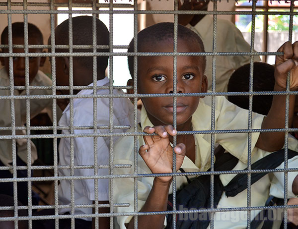 Uma criança na janela de sua escola em Zanzibar