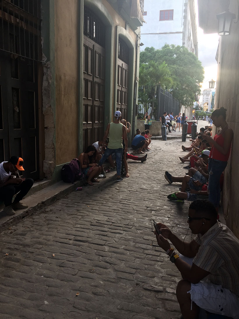 Pessoas conectadas à internet em uma rua no centro de Havana