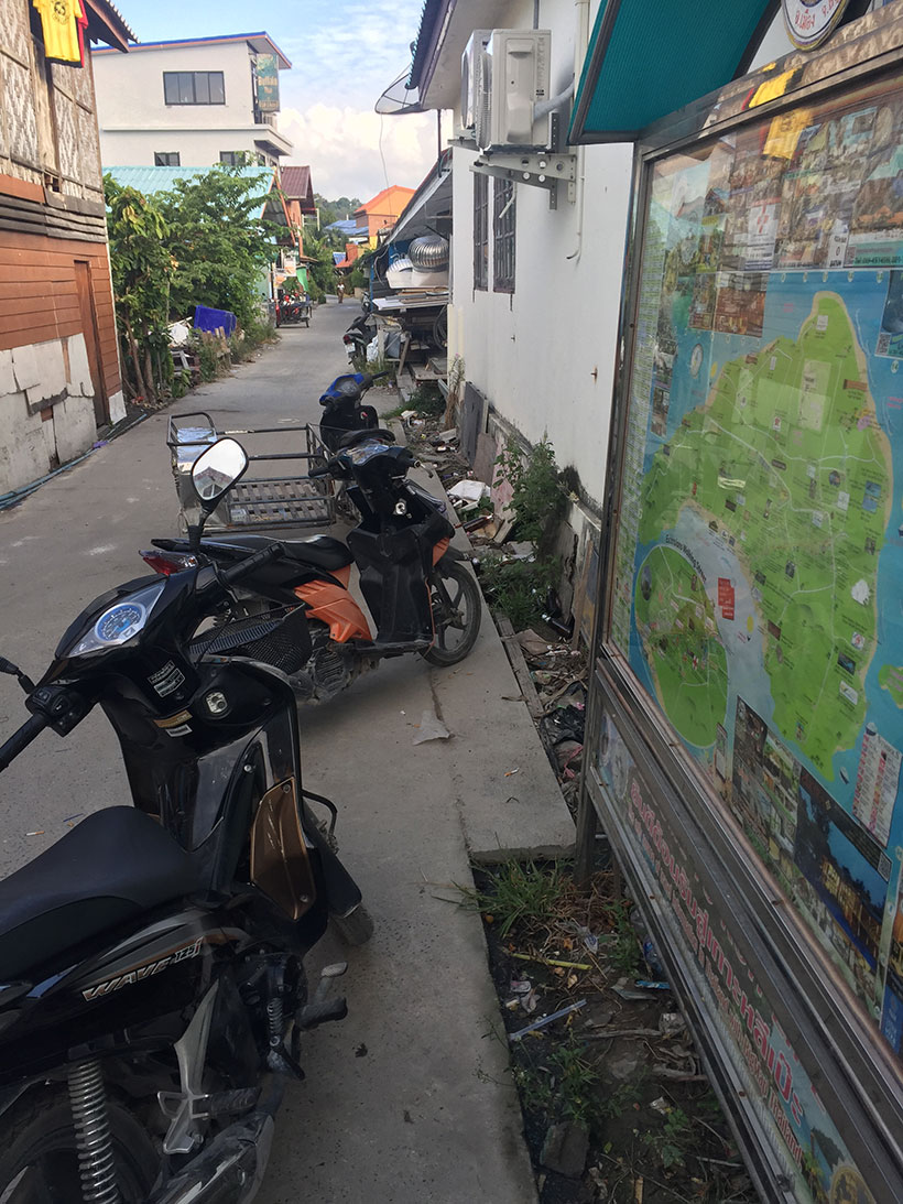 Motos e sujeira em esgoto ao céu aberto na ilha de Koh Lipe
