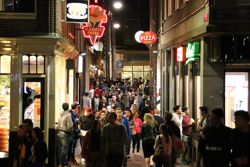 Rua repleta com restaurantes na Capital da Holanda